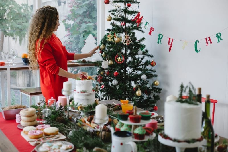 girl in red dress decorate the tree